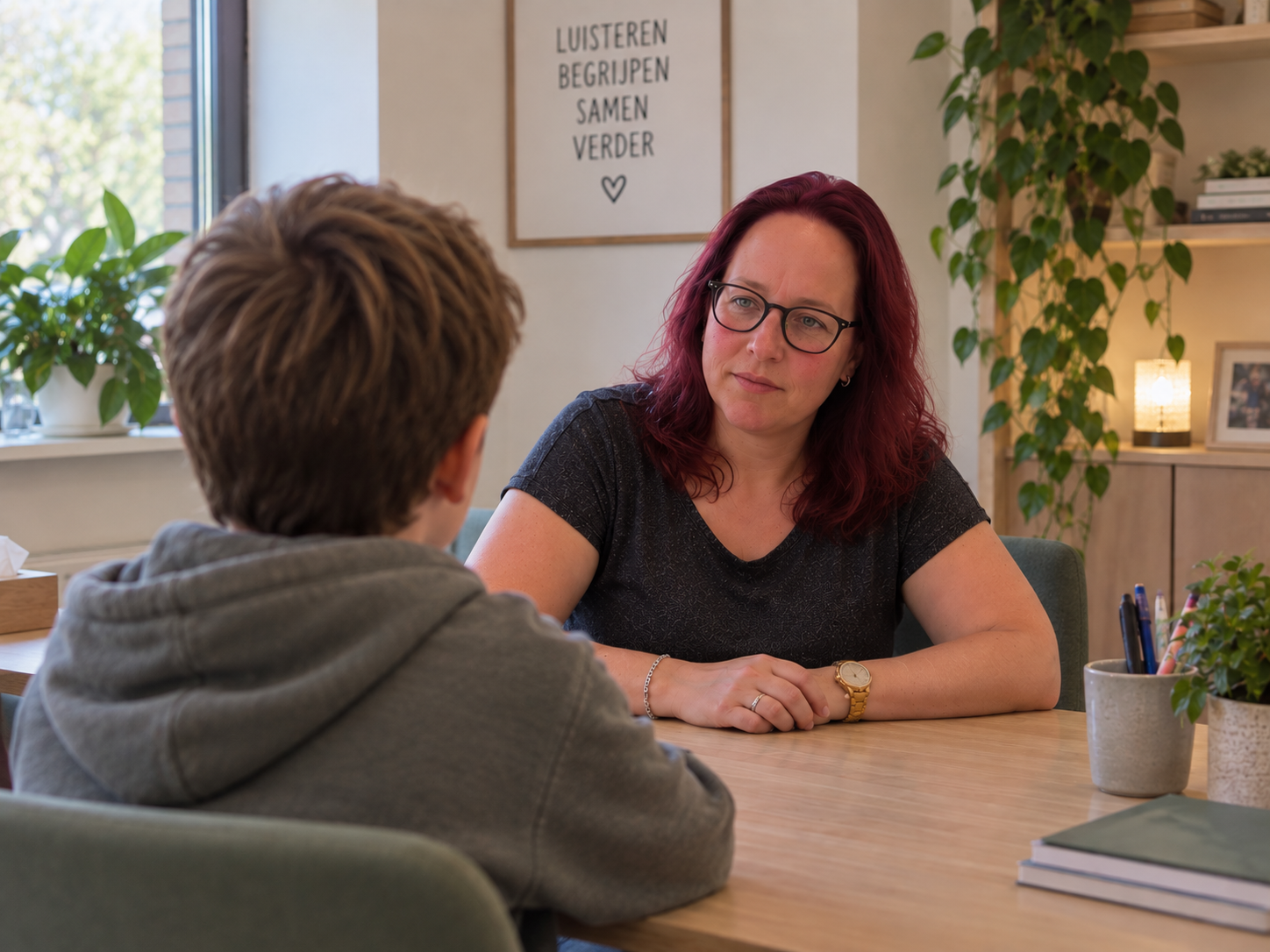 Twee zorgprofessionals in gesprek met een jongere aan tafel